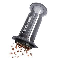 Naklonený AeroPress Original s kvapkami kávy na bielom pozadí